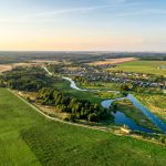 Aerial view. Small european village. Blue winding river.