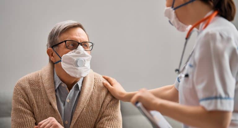 Doctor and senior man wearing facemasks